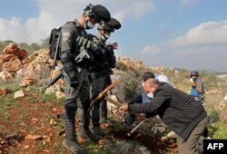 Polisi Israel mengamati petani Palestina yang menanam bibit pohon zaitun di Tepi Barat (foto: dok).