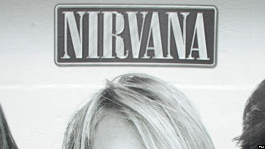 Seorang pejalan kaki melewati poster Kurt Cobain, vokalis dan gitaris Nirvana, di kota Seattle (foto: dok).