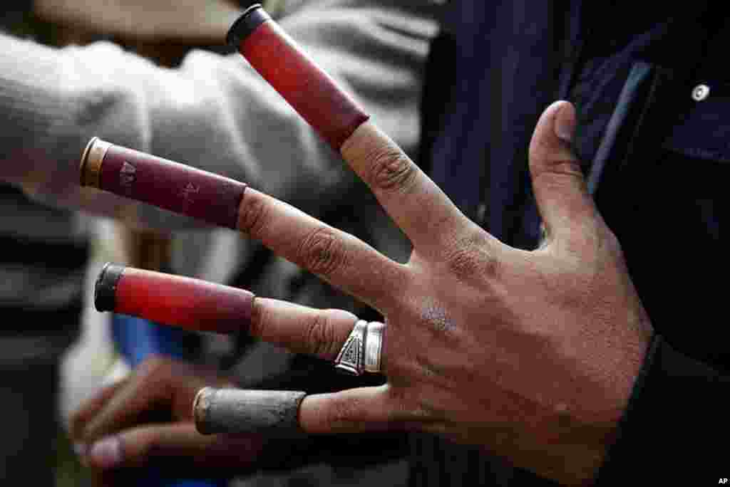 A protester on near Tahrir Square with spent shotgun shells on his fingers. (VOA - Y. Weeks)