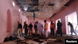 Police officers and rescue workers gather at the site after a blast in a mosque in Quetta, Pakistan, May 24, 2019. 