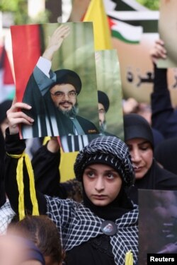 FILE - Hezbollah supporters carry banners depicting Hezbollah senior official Sayyed Hashem Safieddine at a protest against a deadly blast at Al-Ahli hospital in Gaza that Israeli and Palestinian officials blamed on each other, in Beirut's suburbs, Lebanon, October 18, 2023.