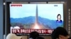 2026년 10월 3일, 서울역에서 방영 중인 뉴스 프로그램 TV 화면에 북한의 미사일 발사 자료 사진이 나오고 있다. 