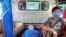 FILE - A relative sits with a COVID-19 patient being taken to hospital in the town of Kale, Sagaing region, Myanmar, July 6, 2021.