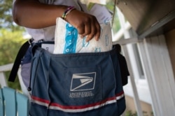 Brandis Neal, empleado del Servicio Postal de los Estados Unidos (USPS), entrega un paquete de Amazon Prime en Houston, Texas, EE. UU., El 18 de agosto de 2020.