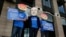 FILE - A protester wearing a mask with the face of Facebook founder Mark Zuckerberg is flanked by two fellow activists wearing angry face emoji masks, during a protest against Facebook policies, in London, Britain, April 26, 2018.