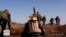 FILE - This file image posted on the Twitter page of Syria's al-Qaida-linked Nusra Front on June 14, 2016, which is consistent with AP reporting, shows Nusra Front fighters moving forward to fight against Syrian troops
