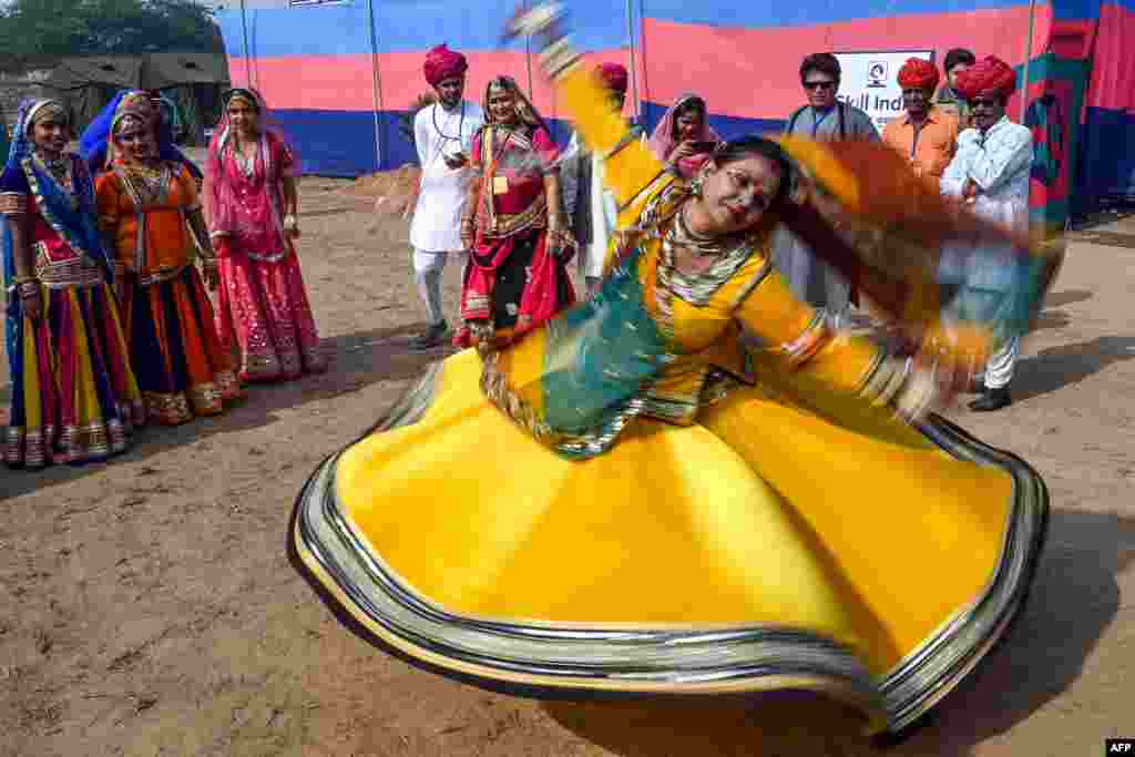Performers wearing traditional outfits from Rajasthan state dance during a press preview of tableaux participating in the forthcoming Republic Day parade in New Delhi.