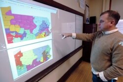 William Marx points to old GOP-drawn Pennsylvania districts (top), which were struck down by a Democratic-majority state Supreme Court, and new re-drawn districts (bottom) in his Pittsburgh classroom, Nov. 16, 2018.