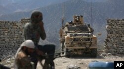 FILE - U.S. forces and Afghan security police are seen in Asad Khil near the site of a U.S. bombing in the Achin district of Jalalabad, east of Kabul, Afghanistan, April 17, 2017. 