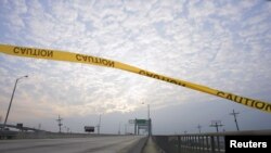 FILE - Caution tape floats in the wind over a walkway running alongside the Danziger Bridge in eastern New Orleans, Louisiana, Nov. 10, 2005.