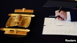 FILE - Czech Culture Minister Antonin Stanek signs a document during the cabinet's inauguration at Prague Castle in Prague, Czech Republic, June 27, 2018. 