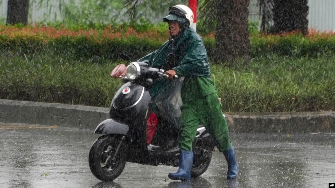 “摩羯”颱風星期六下午1時在越南北部島嶼登陸，強風豪雨下，河內一名男子被破牽引機車。(美聯社：2024年9月7日)