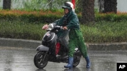 “摩羯”台风星期六下午1时在越南北部岛屿登陆，强风豪雨下，河内一名男子被破牵引机车。(美联社：2024年9月7日)