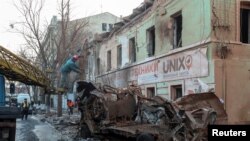 FILE - Municipal workers remove debris at a site of a Russian missile strike, amid Russia's attack on Ukraine, in central Kharkiv, Ukraine, Jan. 17, 2024.