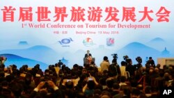 China's Premier Li Keqiang, center, delivers a speech at the First World Conference on Tourism for Development at the Great Hall of the People in Beijing Thursday, May 19, 2016. 