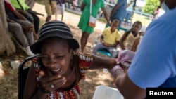 A woman injured after Saturday's 7.2 magnitude quake reacts while being treated at the Ofatma Hospital, in Les Cayes, Haiti, August 18, 2021. 