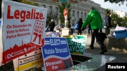 FILE - Pedestrians pass by a DC Cannabis Campaign sign in Washington, Nov. 4, 2014. 