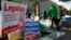 FILE - Pedestrians pass by a DC Cannabis Campaign sign in Washington, Nov. 4, 2014. 