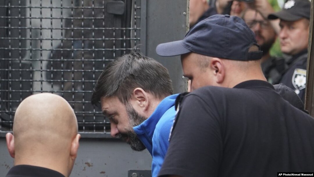 Kirill Vyshinskiy, pimpinan kantor Ukraina di RIA Novosti (kantor berita Rusia) di Ukraina, dikawal dari ruang pengadilan di Kiev, Ukraina, 15 Juli 2019.