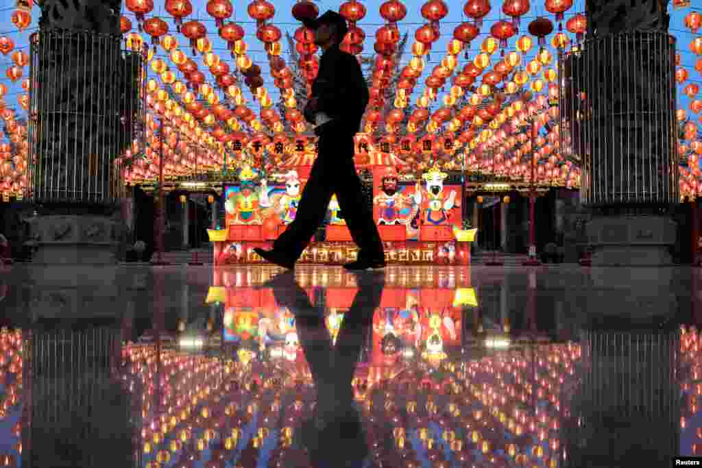 A man walks under lanterns and decorations to celebrate the upcoming Lunar New Year of Rooster at a shrine on the outskirts of Bangkok, Thailand January 25, 2017..