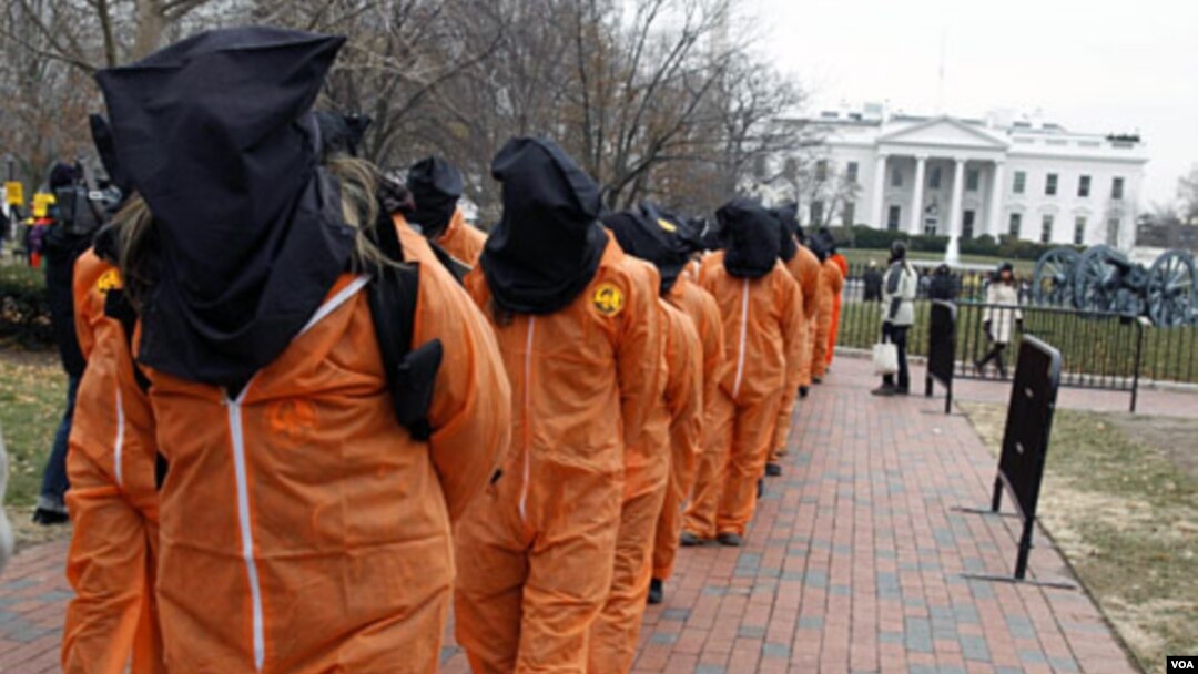 Para demonstran mengenakan pakaian tahanan saat berdemonstrasi di depan Gedung Putih, 11 Januari 2011, bertepatan 9 tahun peringatan pembukaan penjara Guantanamo.