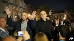 Alexei Navalny (kiri) blogger oposisi terkemuka, dan pemimpin oposisi Sergei Udaltsov memberikan pidato dalam aksi unjuk rasa anti-Putin di Moskow (8/5).