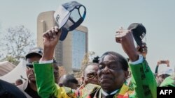 FILE - Zimbabwean President and ZANU PF leader Emmerson Mnangagwa (C) raises his cap in salute to the crowd gathered during a rally in Harare on August 9, 2023.