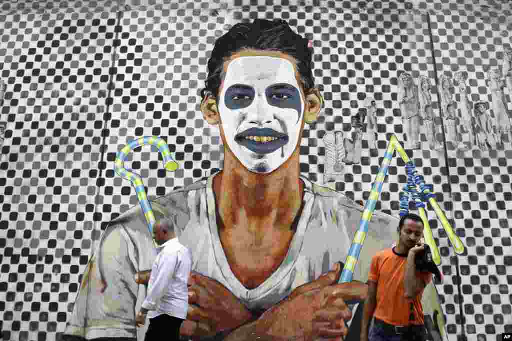 Egipćani prolaze pokraj grafitija sa modernim i faraonskim motivima u blizini Trga Tahrir, u Kairu. 