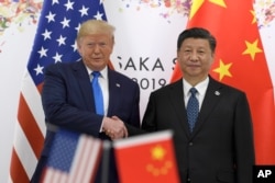 FILE - President Donald Trump, left, shakes hands with Chinese President Xi Jinping during a meeting on the sidelines of the G-20 summit in Osaka, Japan, June 29, 2019.