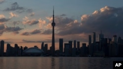 ARCHIVO - El sol se pone sobre el horizonte de Toronto durante la ceremonia de apertura de los Juegos Panamericanos, el 10 de julio de 2015.