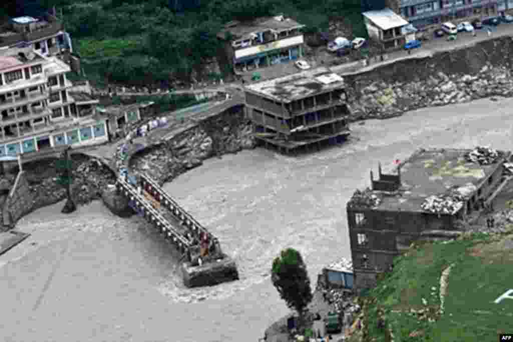 Pakistani flood survivors lineup beside the damage bridge in Medain, a town of Swat valley on August 2, 2010. Fears are growing about outbreaks of disease among 2.5 million people affected by Pakistan's worst floods in 80 years after monsoon rains killed