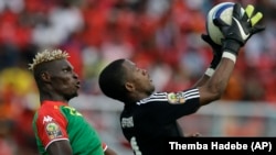 Burkina Faso’s Aristide Bance, left, is stopped in the air by Equatorial Guinea's goalkeeper Felipe Ovono, right, Wednesday, Jan. 21, 2015. (AP)