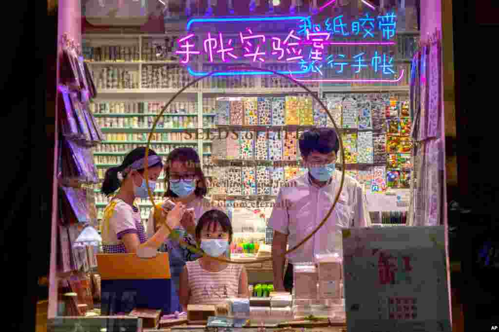 People wearing face masks to protect themselves against the coronavirus shop in a store along a pedestrian shopping street in Beijing, China.