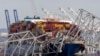 FILE - The cargo ship Dali is stuck under part of the structure of the Francis Scott Key Bridge after the ship hit the bridge, March 26, 2024, as seen from Pasadena, Maryland.