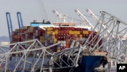 FILE - The cargo ship Dali is stuck under part of the structure of the Francis Scott Key Bridge after the ship hit the bridge, March 26, 2024, as seen from Pasadena, Maryland.