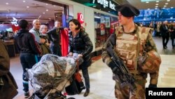 Seorang tentara Perancis berpatroli di sebuah mall di Lyon (16/1) sebagai bagian dari siaga keamanan "Vigipirate" sesudah terjadinya serangan teroris minggu lalu. 