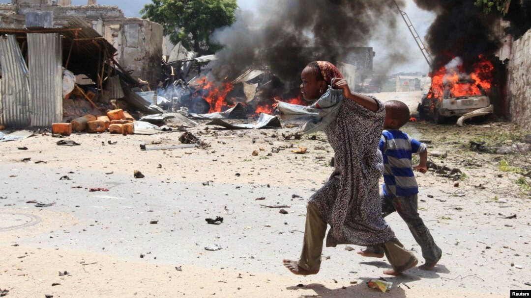 Dua orang anak Somalia lari menyelamatkan diri saat terjadinya ledakan di komplek pengadilan di Mogadishu, Minggu (14/4).