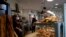 Bakers sell bread in a Boulogne Billancourt bakery, outside Paris, March 24, 2020. 