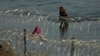 Un migrante camina hacia la frontera de Estados Unidos bordeada de alambre de púas, el lunes 31 de julio de 2023, cerca de Eagle Pass, en Texas. 
