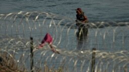 Un migrante camina hacia la frontera de Estados Unidos bordeada de alambre de púas, el lunes 31 de julio de 2023, cerca de Eagle Pass, en Texas. 