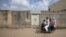A family rides past the locked house of Rimsha Masih, a Pakistani Christian girl accused of blasphemy, on the outskirts of Islamabad, August 23, 2012.