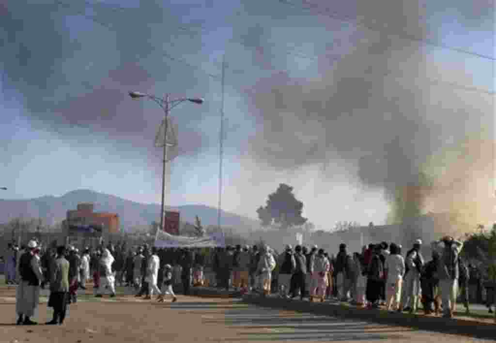 Smoke rises from the UN's office following a demonstration to condemn the burning of a copy of the Muslim holy book by a U.S. Florida pastor, in Mazar-i- Sharif north of Kabul, Afghanistan, on Friday, April 1, 2011. An Afghan official says seven people ha