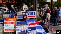 FILE - Voters wait in line to cast their ballots on the second day of early voting in in Noblesville, Indiana, Oct. 7, 2020.