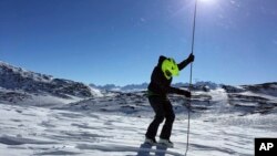 This April 2017 photo by the Alaska Division of Geological and Geophysical Surveys shows geologist Katreen Wikstrom Jones using an avalanche probe to measure snow depth at Thompson Pass, Alaska. Researchers in the Pacific Northwest and Alaska are looking for backcountry enthusiasts who want to aid a science mission.