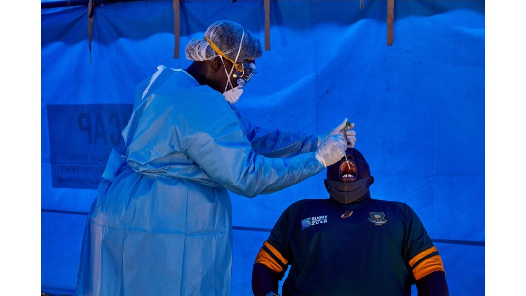 FILE - A member of South Sudanese Ministry of Health's Rapid Response Team take a sample from a man who had recently been in contact with a confirmed case of the COVID-19 coronavirus in Juba, South Sudan, April 13, 2020.