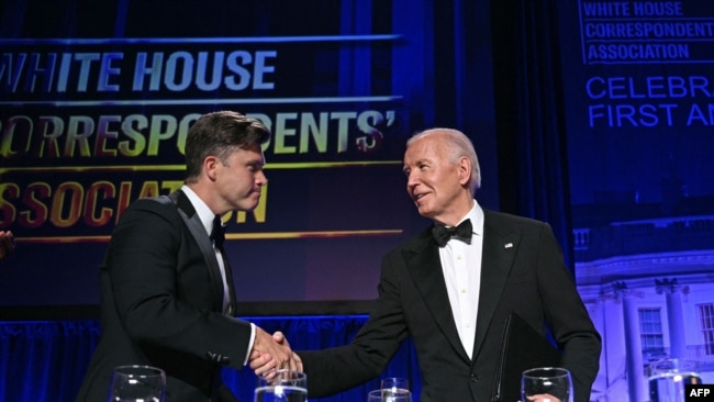 El presidente estadounidense Joe Biden saluda al comediante estadounidense Colin Jost (R) durante la cena de la Asociación de Corresponsales de la Casa Blanca (WHCA) en el Washington Hilton, en Washington, DC, el 27 de abril de 2024