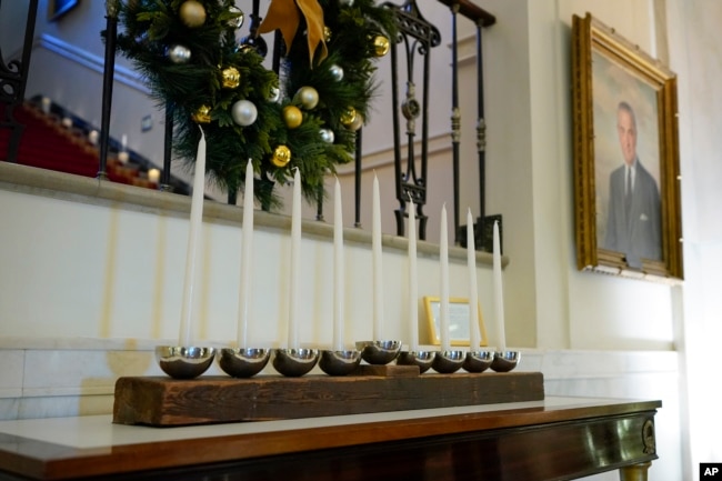 A menorah that was built by White House carpenters from wood that was removed during a Truman-era renovation is on display in Cross Hall of the White House during a press preview of holiday decorations at the White House on November 28, 2022, in Washington. (AP Photo/Patrick Semansky)