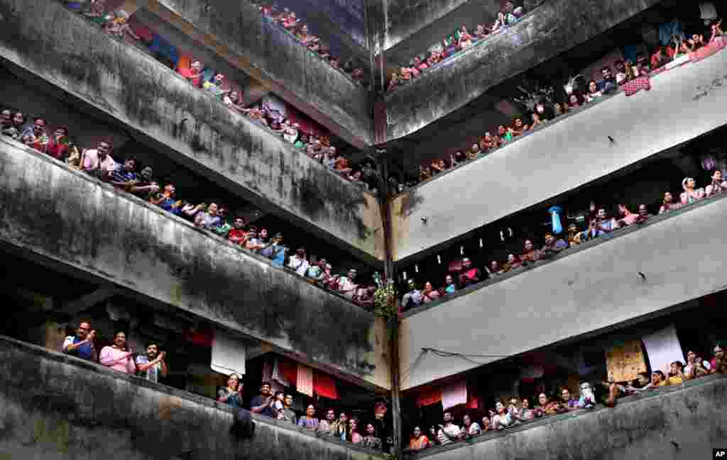 People clap from balconies in show of appreciation to health care workers at a Chawl in Mumbai. India observed a 14-hour &quot;people&#39;s curfew&quot; called by Prime Minister Narendra Modi in order to stem the rising coronavirus case in the country.