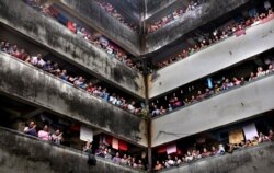 People clap from balconies in show of appreciation to health care workers at a Chawl in Mumbai, India, March 22, 2020.