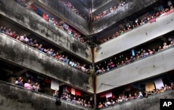 People clap from balconies in show of appreciation to health care workers at a Chawl in Mumbai, India, March 22, 2020.